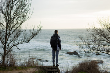 the sports guy is standing on the edge of a cliff