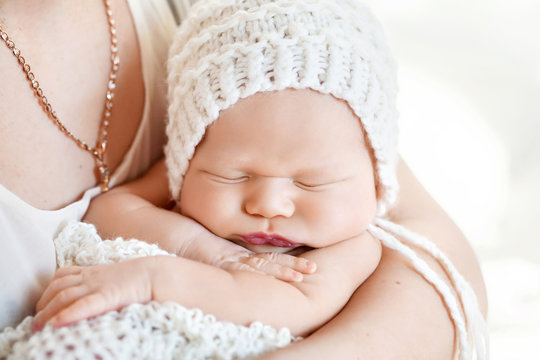 Loving baby sleeping in mother's hands. Closeup picture