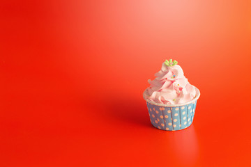 Tasty Birthday cupcake on red color background