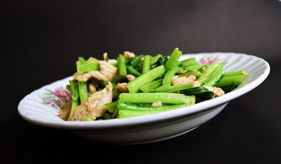 Cantonese vegetables,Fried pork with bok choy and garlic in the dish on black background,Chinese food,Thailand 
