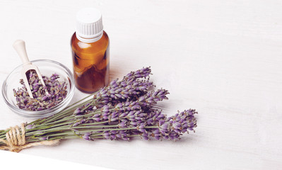 Fototapeta na wymiar Lavender oil with fresh lavender on a wooden background