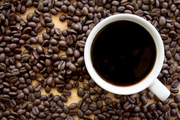 Black coffee in white cup with coffee beans