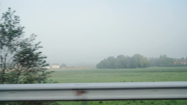 Green countryside in fog from car side view in slow motion 4K