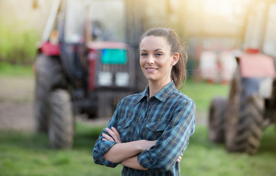 Farmer woman with tractors on farmland