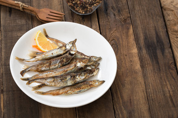 Grilled fish capelin or shishamo on white plate

