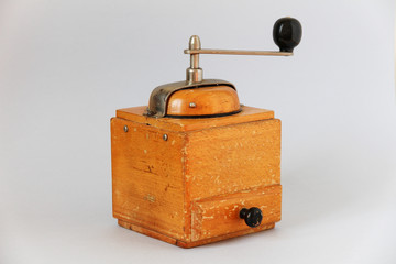 vintage old wooden coffee grinder. manual grinding. light background