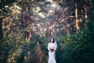Fototapeta premium Beautiful bride outdoors in a forest.