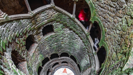 The Initiation Well pattern with blurred tourists descending