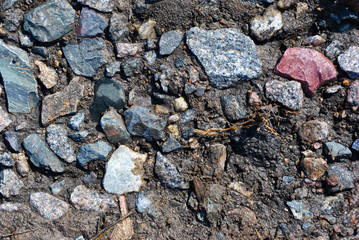 Colorful crushed stone on ground road, grunge background texture, horizontal top view