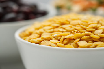 Yellow lentils in a white bowl macro shot, selective focus