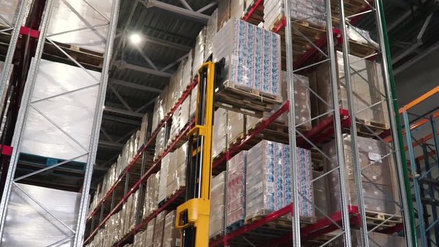Lift truck in factory. Clip. Wholesale logistic, loading, shipment and people concept - man with loader carrying cargo at warehouse