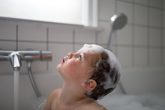 Baby boy taking a bath in bathtub