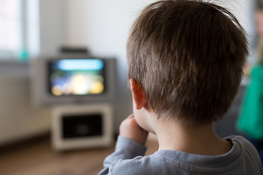 Rear view of boy watching television
