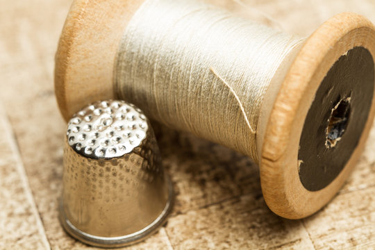 Hilo antiguo y dedal de metal. Vista de frente y de cerca. Concepto: Costura
