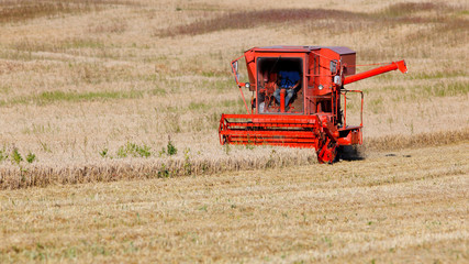Combine harvester of very old model working in field