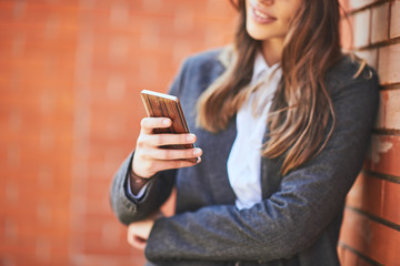 Woman using smart phone outdoors. Selective focus on smart phone.