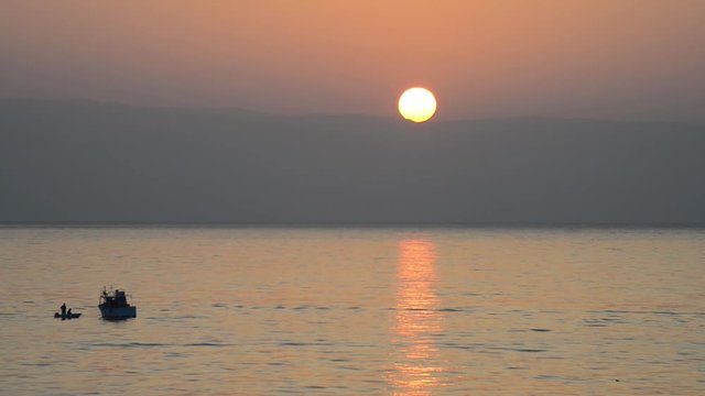 Prime luci del giorno con natanti e pescatori al lavoro