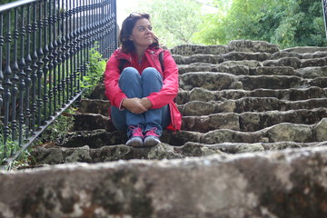 Mujer joven esperando sentada en unas escaleras