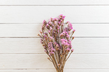 Bouquet of dried flowers on white wooden planks background