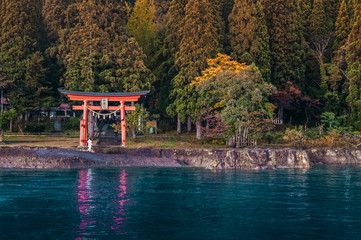 Red Torii of Gozanoishi Shrine at Lake Tazawa ko, Senboku, Akita, Japan. Japanese  characters on...