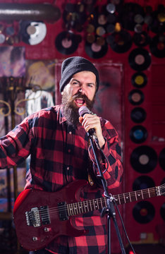 Musician with beard play electric guitar instrument.
