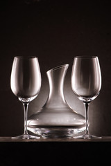 empty decanter between two wineglasses on black
