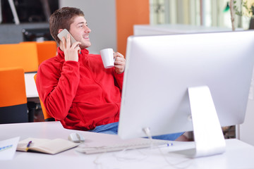 Obraz premium Happy young business man work in modern office on computer