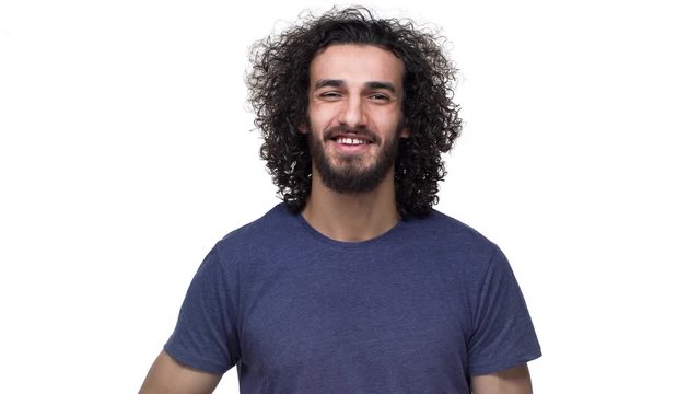 Portrait of attractive bearded guy in casual grinning and showing finger on camera meaning hey lucky you, isolated over white background. Concept of emotions