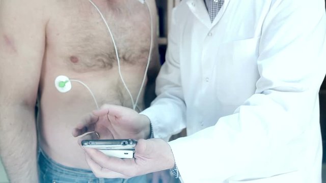 A Doctor demonstrates a cardiogram on the mobile phone