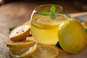 Naklejka na ściany i meble Lemon juice with honey on wooden table, lemons and sage leaves