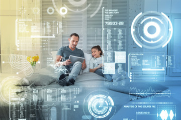 Unbelievable opportunities. Little emotional girl relaxing on the bed and feeling impressed by the...