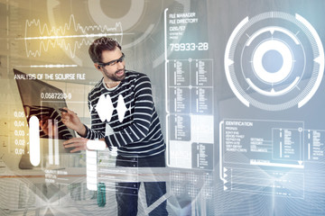Obraz premium Working process. Enthusiastic young creative programmer wearing virtual reality glasses and holding a modern stylus while working