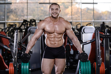 Fototapeta na wymiar Brutal strong bodybuilder athletic men pumping up muscles with dumbbells
