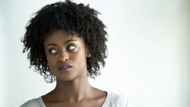 Displeased young woman with afro, studio shot.