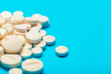 Pills are scattered over a blue background