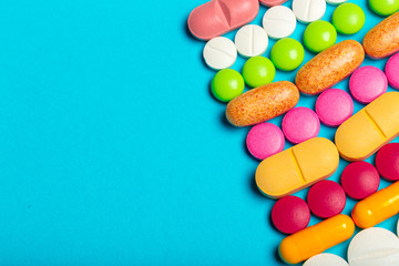 Pills are scattered over a blue background