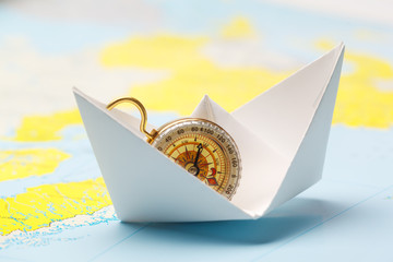 Origami paper ship on a map. Leadership and travelling concept
