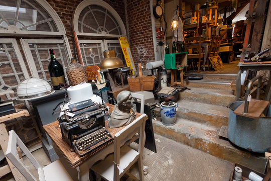 Old antique store with many vintage utensil, decor, wooden furniture, retro typewriter and many details