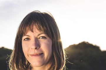 Sunlit brunette girl. Close-up of a normal woman