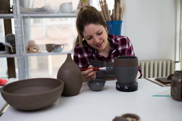 Young woman making a ceramic mold, at her workshop. 