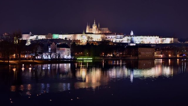 Timelapse of Vltava river at charles bridge and prague castle at night with reflections, czech republic