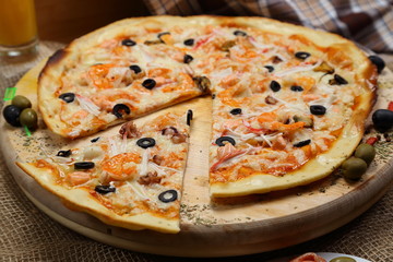 pizza thin olive shrimp crabs on a wooden stand 