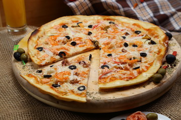 pizza thin olive shrimp crabs on a wooden stand 