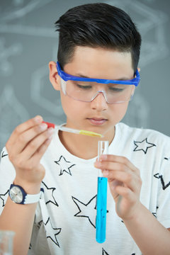 Asian Teenager Carrying out Experiment