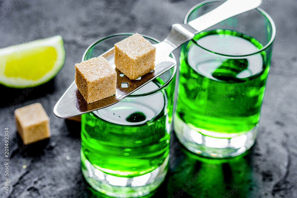 Wall mural absinthe shots with lime slices and sugar on dark table backgrou