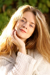 Portrait of beautiful young woman with blonde hair in autumn