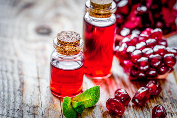 sliced pomegranate and extract in glass on wooden background