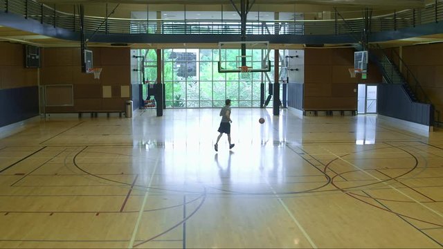 Young man playing basketball by himself