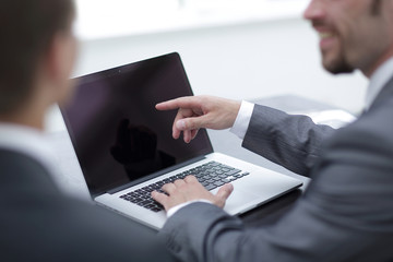 closeup. business colleagues discussing information with a laptop.