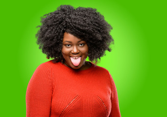 Beautiful african woman sticking out tongue at camera at sign of disobedience, protest and...
